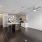Spacious and well lit kitchen with wood flooring and stainless steel appliances
