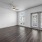 Spacious and well lit living room with wood flooring, large windows and open access to the kitchen