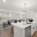 Spacious and well lit living room with wood flooring, large windows and open access to the kitchen