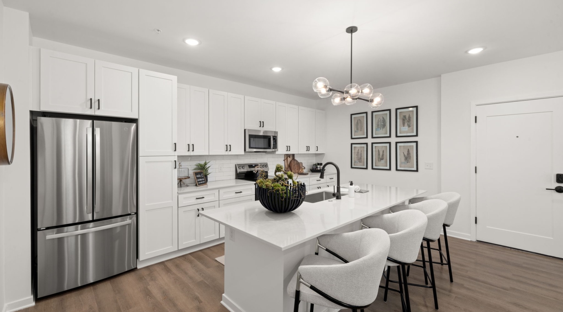 Luxury kitchen with white cabinets and island at District Square Morrisville apartments Luxury kitchen with white cabinets and island at District Square Morrisville apartments