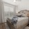 Large well lit bedroom with hardwood floors and large windows 