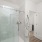 Large well lit bathroom with white accents 