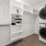 Large closet with custom shelving along with the washer and dryer