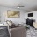 Spacious and well lit living room with wood flooring, large windows and open access to the kitchen