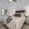 Large well lit bedroom with plush carpets and large windows 